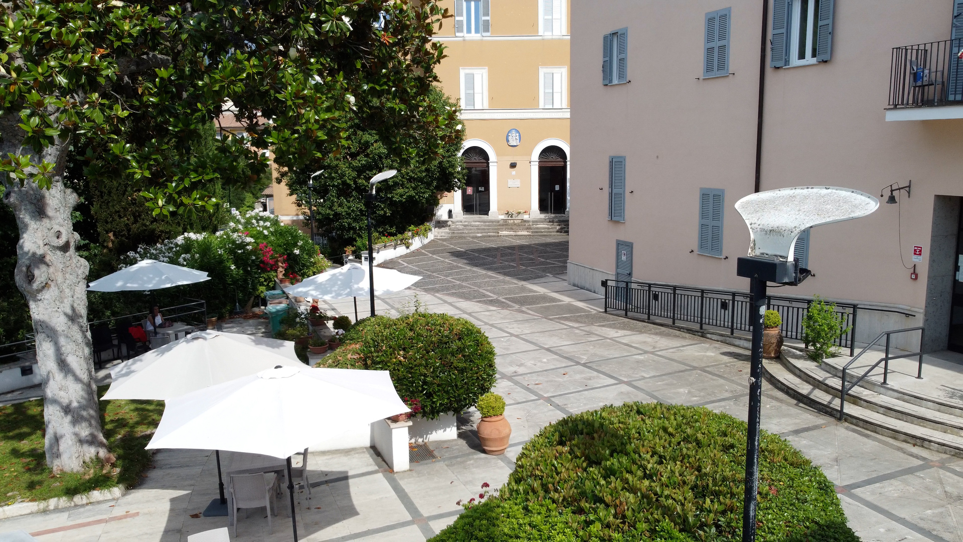 Cortile esterno con tavoli e ombrelloni